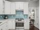 Bright kitchen boasts white cabinets, quartz countertops, and stainless steel appliances at 510 Rosedown Way, Alpharetta, GA 30022