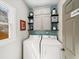 Functional laundry room with overhead cabinets, shelving, and modern washer and dryer units at 510 Rosedown Way, Alpharetta, GA 30022