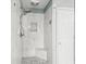 Modern shower featuring marble tile, a built-in seat, and a handheld shower head at 510 Rosedown Way, Alpharetta, GA 30022