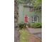 Two-story home with a bright pink door, green siding, and mature landscaping at 6 Holly Downs Nw Ct, Atlanta, GA 30318