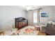 This lovely bedroom features a dark wood crib, bright rug, and lots of natural light through a window at 6640 Stratford Pl, Cumming, GA 30040