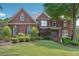 Beautiful red brick home with mature landscaping and a well-manicured lawn at 6640 Stratford Pl, Cumming, GA 30040