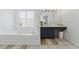 Bright bathroom featuring a soaking tub, vanity with good lighting, and tiled floor at 6640 Stratford Pl, Cumming, GA 30040