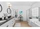 Elegant bathroom with double sinks, black countertops, and a glass-enclosed shower and tub at 912 Santa Anita Dr, Woodstock, GA 30189