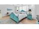 Bright bedroom features an aqua blue bed frame, white linens, and light hardwood floors at 912 Santa Anita Dr, Woodstock, GA 30189