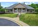 Inviting clubhouse featuring a covered porch, white columns, well-manicured lawn, and American flags at 912 Santa Anita Dr, Woodstock, GA 30189