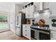 Modern kitchen featuring stainless steel appliances, white cabinets, and a view of the backyard at 912 Santa Anita Dr, Woodstock, GA 30189