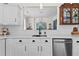 Bright kitchen with white cabinets, stainless appliances, and hardwood floors with a view to the dining room at 912 Santa Anita Dr, Woodstock, GA 30189