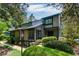 Two story home featuring a charming design and lush landscaping with mature trees and manicured bushes at 3102 Balearic Se Dr, Marietta, GA 30067