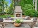 A welcoming backyard patio area with an outdoor fireplace and comfortable seating in a lush, green setting at 4643 River Ct, Peachtree Corners, GA 30097