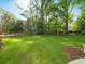 Expansive green backyard with lush lawn, mature trees, and manicured landscaping, offering privacy and space at 4643 River Ct, Peachtree Corners, GA 30097