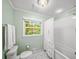 Bright bathroom featuring white marble floors, a tub/shower combo, and a window offering outdoor views at 4643 River Ct, Peachtree Corners, GA 30097