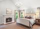 A beautifully designed bedroom featuring a fireplace, chandelier, and neutral tones at 4643 River Ct, Peachtree Corners, GA 30097