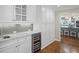 Butler's pantry with white cabinets, marble countertops, and stainless steel wine fridge at 4643 River Ct, Peachtree Corners, GA 30097
