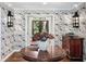 Inviting entryway with floral wallpaper, dark hardwood floors, and decorative sconces at 4643 River Ct, Peachtree Corners, GA 30097