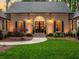 Close-up of the front door with decorative lighting, landscaping and well-kept lawn at 4643 River Ct, Peachtree Corners, GA 30097