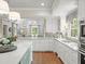 Bright kitchen features white cabinets, gray countertops, and stainless faucet at 4643 River Ct, Peachtree Corners, GA 30097