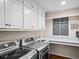 Well-equipped laundry room with modern washer/dryer, sink, counter, and ample storage cabinets at 4643 River Ct, Peachtree Corners, GA 30097