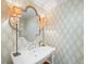 Stylish powder room featuring designer wallpaper, elegant mirror, and decorative lighting at 4643 River Ct, Peachtree Corners, GA 30097