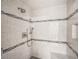 Tiled shower with gray accent stripes and two shower heads and built in niche at 4643 River Ct, Peachtree Corners, GA 30097