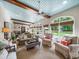 Light-filled sunroom with beamed ceiling, large windows, and comfortable seating area at 4643 River Ct, Peachtree Corners, GA 30097