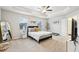 Spacious bedroom featuring a tray ceiling, soft carpet, and an ensuite bathroom at 5575 Rock Place Ct, Norcross, GA 30093