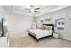 Bright main bedroom showcasing a tray ceiling, a ceiling fan, and a cozy aesthetic at 5575 Rock Place Ct, Norcross, GA 30093