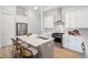 Bright kitchen features an island with seating, stainless steel appliances, white cabinets and quartz countertops at 677 Stickley Oak Way, Woodstock, GA 30189