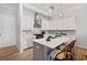 Bright kitchen features an island with seating, stainless steel appliances, white cabinets and quartz countertops at 677 Stickley Oak Way, Woodstock, GA 30189