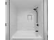 A bathtub and shower combination with marble tile and a black shower head at 6851 Roswell Rd # O-26, Atlanta, GA 30328
