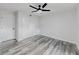 Bright bedroom with a ceiling fan, closet, door, and gray wood-look flooring at 6851 Roswell Rd # O-26, Atlanta, GA 30328