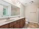 Bathroom with double sink vanity, granite countertop, large mirror, and tiled floor at 1647 Shire Village Dr, Sugar Hill, GA 30518
