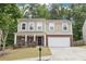Charming two-story home with a brick facade, a well-manicured lawn, and inviting curb appeal at 1647 Shire Village Dr, Sugar Hill, GA 30518