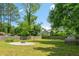 Large backyard with mature trees, a circular fire pit area, and a wood fence line at 1798 S Gordon Sw St, Atlanta, GA 30310