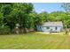 Large backyard featuring lush lawn, mature trees, and a charming blue home at 1798 S Gordon Sw St, Atlanta, GA 30310