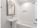 Bright bathroom featuring a white vanity, a framed mirror, and a bathtub with white subway tile at 1798 S Gordon Sw St, Atlanta, GA 30310