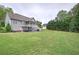 Spacious backyard featuring a lush lawn, mature trees, and a home with a screened porch and a detached garage at 18 Spring Lake Ne Trl, White, GA 30184