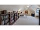Spacious bonus room with neutral carpet, vaulted ceilings, and extensive built-in bookshelves for storage at 18 Spring Lake Ne Trl, White, GA 30184