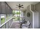 Inviting screened porch with two chairs, side table, fan, and retractable shades for added comfort at 18 Spring Lake Ne Trl, White, GA 30184