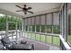 Relaxing screened porch with comfortable seating and roll down shades providing an indoor-outdoor living space at 18 Spring Lake Ne Trl, White, GA 30184