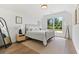 Bright bedroom with a large window, a metal bed frame, and hardwood floors at 3610 Burnt Bridge Rd, Cumming, GA 30028