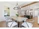 Bright dining room with hardwood floors, modern chandelier, and a view into the living space at 3610 Burnt Bridge Rd, Cumming, GA 30028