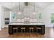 Bright kitchen featuring a large dark island, white cabinets, stainless steel appliances, and pendant lighting at 3610 Burnt Bridge Rd, Cumming, GA 30028