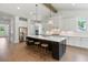 Large bright kitchen featuring a dark island, white cabinets, stainless steel appliances, and hardwood floors at 3610 Burnt Bridge Rd, Cumming, GA 30028