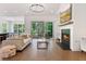 Open-concept living room, kitchen, and dining area with hardwood floors, a fireplace, and bright lighting at 3610 Burnt Bridge Rd, Cumming, GA 30028