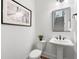 Stylish powder room with pedestal sink, decorative mirror, and modern lighting at 3610 Burnt Bridge Rd, Cumming, GA 30028
