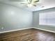Bright, cozy bedroom featuring wood-look floors, a ceiling fan, and a large window at 3647 Diamond Cir, Decatur, GA 30034