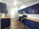 Modern kitchen featuring blue cabinets, wood countertops, and stainless steel appliances at 3647 Diamond Cir, Decatur, GA 30034