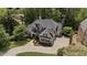 Aerial view showing an elegant home with a well-maintained landscape and a paved driveway at 5293 Aldeburgh Dr, Suwanee, GA 30024