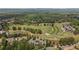 Aerial view of property located on a golf course surrounded by lush greenery and mature trees at 5293 Aldeburgh Dr, Suwanee, GA 30024